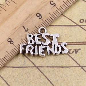 以下が含まれることがあります： スタイリッシュなフォントで「BEST FRIENDS」と書かれたシルバーチャーム