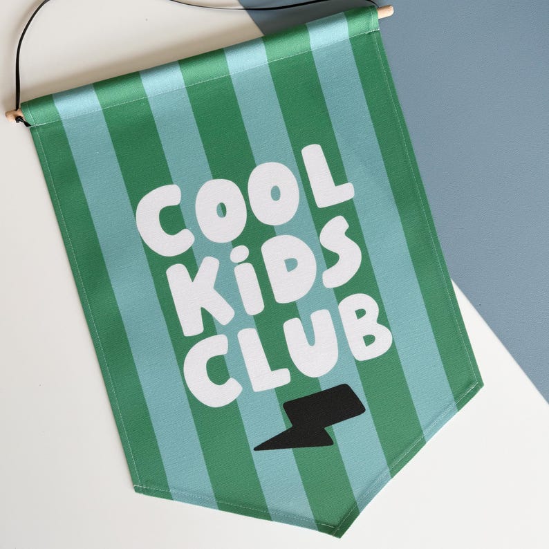 May include: Green and blue striped fabric banner with the text "COOL KIDS CLUB" in white and a black lightning bolt graphic.