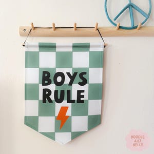 May include: A green and white checkered banner with the text "BOYS RULE" in black letters and a lightning bolt in orange.