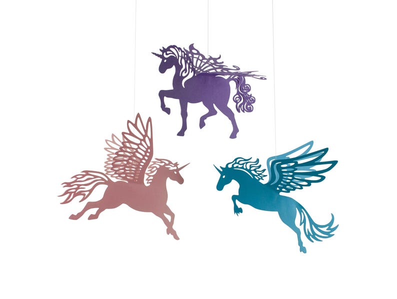 Vliegende papieren eenhoorns met decoratieve vleugels. Deze hangen aan een transparant draadje zodat ze als decoratie kunnen worden opgehangen. De huidige kleren zijn paars, blauw en roze, maar kunnen in elke kleur gemaakt worden.
