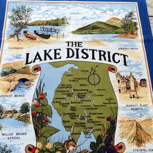 May include: A colorful tea towel with a map of the Lake District in England. The map shows the location of various towns and lakes, including Ullswater, Derwent Water, and Keswick Lake. The tea towel also features illustrations of bridges, mountains, and other landmarks.