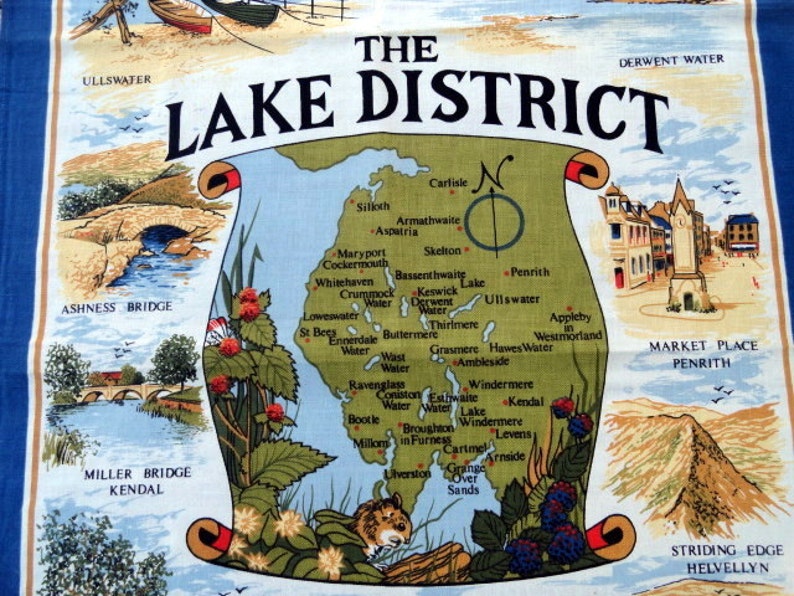 May include: A colorful map of the Lake District in England, with a compass rose and the words "The Lake District" in a banner at the top. The map shows the locations of various towns, lakes, and mountains in the region. The map is surrounded by a border of green leaves and berries.