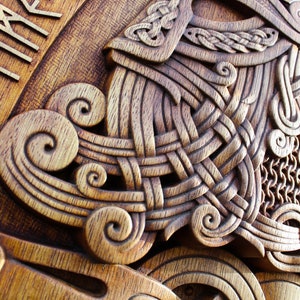 May include: A wooden carving of a Viking helmet with intricate knotwork and a chainmail design. The helmet is surrounded by a border of runes, which read "TIME".