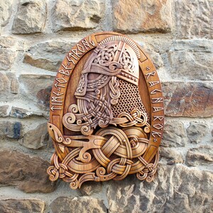 May include: A wooden carving of a Viking warrior's head with a horned helmet, surrounded by intricate knotwork. The carving is mounted on a wall and reads "TIME TO BE STRONG * RAGNAROK *"