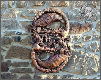 May include: A wooden wall sculpture featuring two stylised ravens intertwined with a tree branch. The sculpture is painted in a copper colour and has a detailed design.