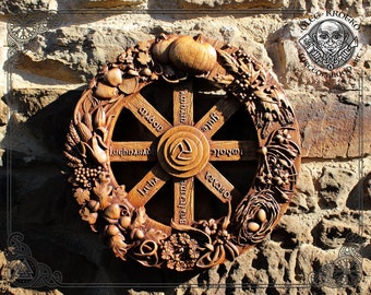 May include: A wooden wheel of the year with carvings of various plants and animals. The wheel is divided into eight sections, each representing a different month of the year. The months are labeled in Old English:  'Imbolc', 'Ostara', 'Beltane', 'Litha', 'Lughnasadh', 'Mabon', 'Samhain', and 'Yule'.