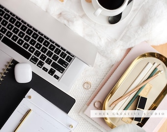 Foto stock di una scrivania da ufficio femminile: fiori, caffè, laptop (immagine digitale)