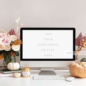 May include: A white desktop computer with a blank screen that says "Add your screenshot or text here" on a white desk with a bouquet of pink and white roses, a vase of dried pampas grass, and three white pumpkins.