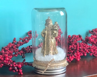 Santa Dry Snowglobe made with Mason Jar and snow fluff, with glittery gold ribbon and twine. Display on Christmas mantel or give as gift
