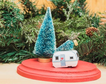 Camper Trailer Holiday Scene Decoration, features a bottlebrush tree with a tiny metal camper, all hand glued on painted wood pedastal