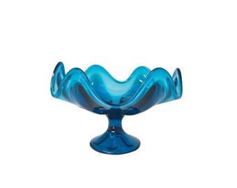 Könnte beinhalten: Eine blaue Glasschüssel mit gewelltem Rand und einem Sockel. Die Schüssel ist perfekt zum Servieren von Obst oder Snacks.