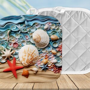May include: A white quilted pot holder with a colorful seashell design. The design features a variety of seashells, starfish, and a red starfish on a sandy background.