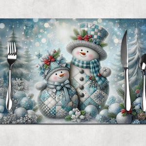 May include: A placemat featuring two snowmen in a winter scene. The snowmen wear hats, scarves, and quilted outfits in shades of blue and white. Silverware, including a fork, knife, and spoon, is placed on the placemat.