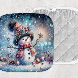 Puede incluir: Un salvamanteles con un muñeco de nieve caprichoso y un reverso acolchado a juego. El muñeco de nieve está adornado con un sombrero, una bufanda y brazos de ramitas, sobre un fondo nevado y borroso. El salvamanteles es cuadrado con un lazo.