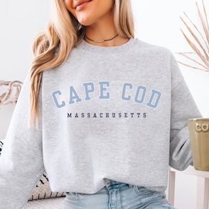 Puede incluir: Una sudadera gris con el texto "CAPE COD MASSACHUSETTS" en letras azules.