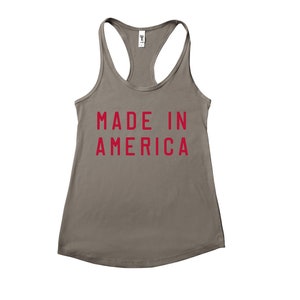 K&ouml;nnte beinhalten: Ein graues Tanktop mit dem Aufdruck "MADE IN AMERICA" in Rot.
