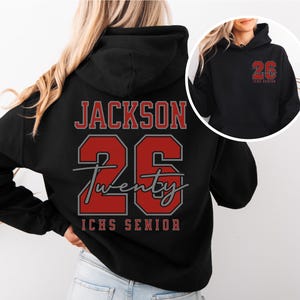 May include: Black hoodie with the name "JACKSON" and the number "26" in red and gray lettering. The word "Twenty" is written in cursive below the number. The text "ICHS SENIOR" is at the bottom. A smaller version of the design is on the front.
