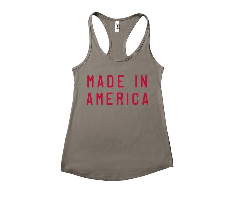 K&ouml;nnte beinhalten: Ein graues Tanktop mit dem Aufdruck "MADE IN AMERICA" in Rot.