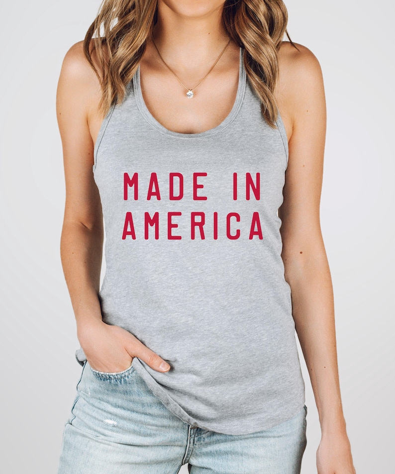 K&ouml;nnte beinhalten: Ein graues Tanktop mit dem Text "MADE IN AMERICA" in Rot.