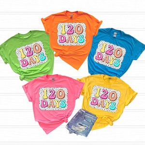 May include: Five t-shirts in different colors with a graphic print of "120 Days" in colorful letters with a white polka dot background.