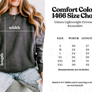 May include: A charcoal gray crewneck sweatshirt with a size chart titled Comfort Colors 1466. The chart lists sizes S through 3XL with corresponding width and length measurements in inches. A diagram on the sweatshirt indicates width and length.