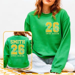May include: Green sweatshirt with the number "26" in yellow, along with the word "Twenty" in script and "GWHS SENIOR". The back of the sweatshirt has the name "SMITH" above the number "26" and "Twenty" and "GWHS SENIOR".