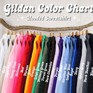 May include: A color chart for Gildan hooded sweatshirts, displaying a variety of colors. The image shows a range of hues, including white, pink, red, orange, green, blue, and black. The text "Gildan Color Chart" and "Hooded Sweatshirt" are visible at the top.