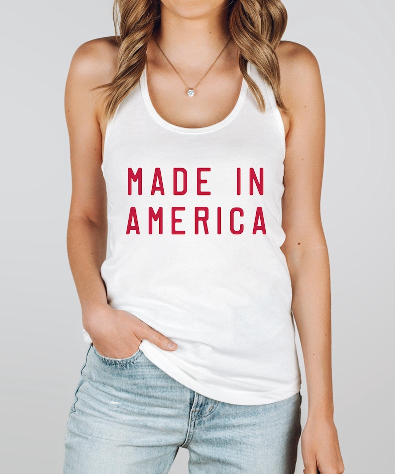 K&ouml;nnte beinhalten: Ein wei&szlig;es Tanktop mit dem Text "MADE IN AMERICA" in Rot.