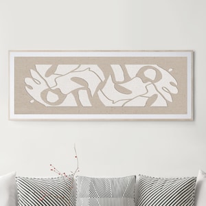 May include: A rectangular wall art piece featuring a light beige background with a white, layered abstract cutout design. The artwork is enclosed in a thin, light-colored wooden frame and is displayed horizontally on a plain white wall.