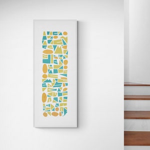 May include: A tall, rectangular framed wall art piece featuring a vertical arrangement of various geometric shapes in shades of teal, light green, and yellow. The composition consists of triangles, circles, and irregular polygons on a white background.