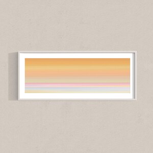 Könnte beinhalten: Ein panoramisches Wandkunst-Druckbild in einem dünnen weißen Rahmen mit einem horizontalen Farbverlauf. Der obere Bereich zeigt warme Orange- und Gelbtöne, die nach unten hin in weiche rosa, hellviolette und blassblaue Streifen übergehen.