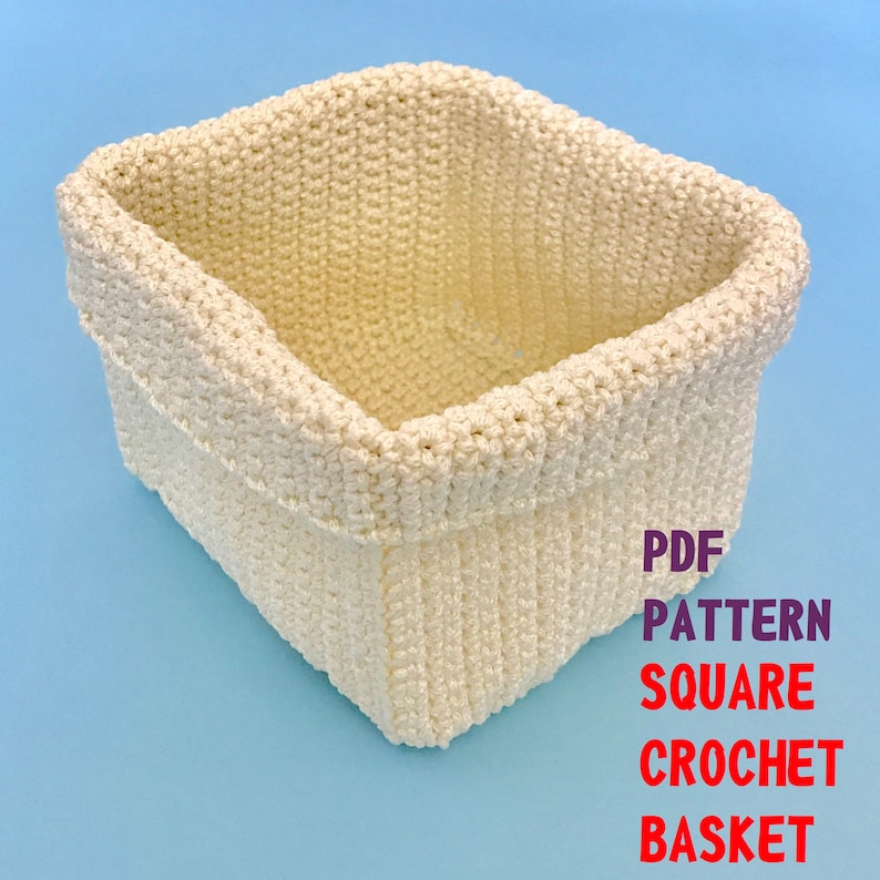 May include: A white crocheted square basket. The basket is made with a simple stitch and has a clean, modern look. PDF PATTERN SQUARE CROCHET BASKET.