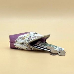 Coin purse clasp bee with contents spilling out.