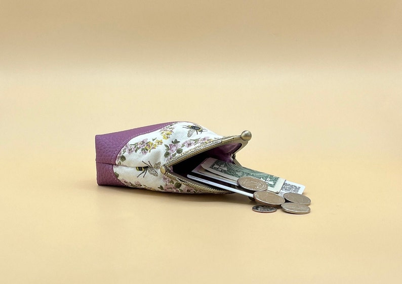 Coin purse clasp bee with contents spilling out.