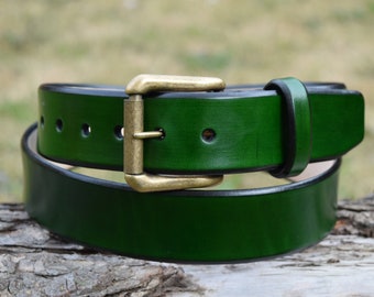 May include: A dark green leather belt with a brass buckle. The belt is folded in half and the buckle is visible in the center of the image.