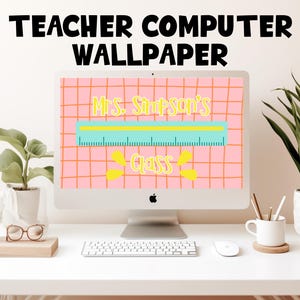 May include: A computer monitor shows a pink grid wallpaper with the text "Teacher Computer Wallpaper." The wallpaper features a ruler design with the text "Mrs. Simpson's Class." A keyboard, mouse, and plants are on the white desk.