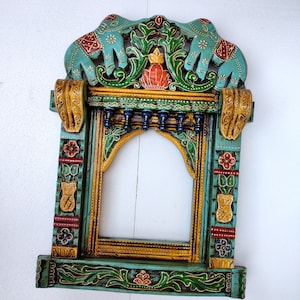 May include: A teal blue wooden frame with intricate carvings of elephants, flowers, and leaves. The frame is painted in gold, red, and green colors.