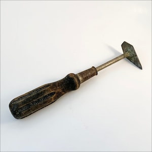 May include: A vintage wood-handled scraper tool with a metal blade. The tool is used for scraping paint, wallpaper, or other materials.