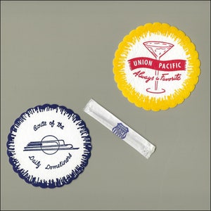 May include: Two round paper coasters with blue and yellow scalloped edges. The blue coaster has the text "Route of the Daily Domeliners" and a stylized train. The yellow coaster has a red ribbon with the text "Union Pacific Always a Favorite" and a martini glass.