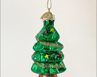 May include: A green glass Christmas tree ornament with gold glitter and red and yellow accents. The ornament has a gold loop for hanging.