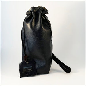 May include: A black leather drawstring bag with a small, rectangular tag that says "Jewell".