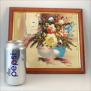 May include: A framed painting of a still life with a bouquet of colorful flowers in two vases. The vases are blue and white and the flowers are pink, yellow, red, and blue. The painting is in a wooden frame.