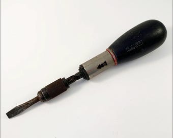 May include: Vintage "YANKEE" Handy screwdriver with a black wooden handle, a silver metal shaft, and a rusty, flathead tip. The handle has the text "YANKEE HANDY" printed on it. The tool is designed for driving screws.