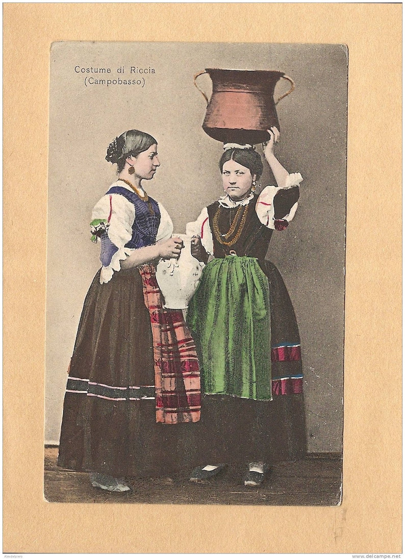 Puede incluir: Dos mujeres con vestimenta tradicional italiana, una llevando una gran olla marr&oacute;n en la cabeza, la otra sosteniendo una jarra blanca. El texto en la postal dice "Costume di Riccia (Campobasso)".