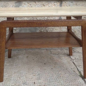 May include: A light wood end table with a lower shelf. The table has a rectangular top and four legs.