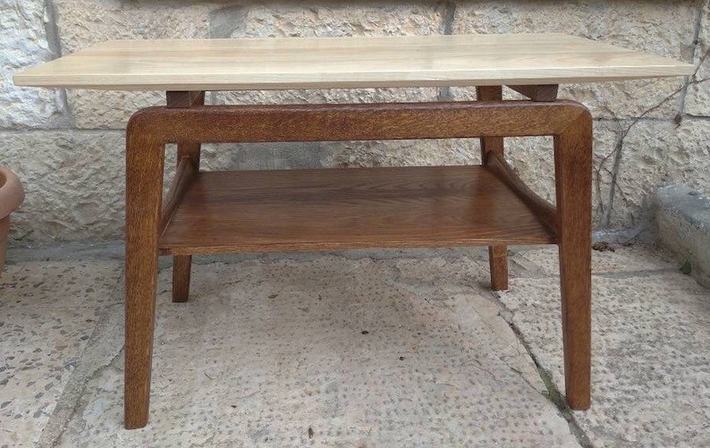May include: A light wood end table with a lower shelf. The table has a rectangular top and four legs.
