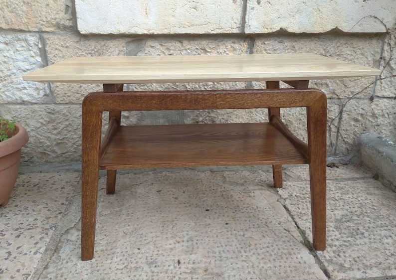May include: A light wood end table with a lower shelf. The table has a simple, modern design with four legs and a rectangular top.