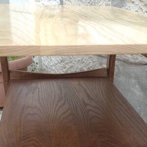 May include: A wooden coffee table with a light wood top and a dark wood bottom shelf. The table has a simple, modern design.