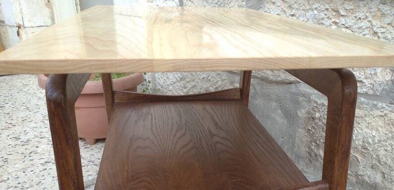 May include: A wooden coffee table with a light wood top and a dark wood bottom shelf. The table has a simple, modern design.
