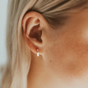 Puede incluir: Primer plano de una oreja con un peque&ntilde;o aro de oro.